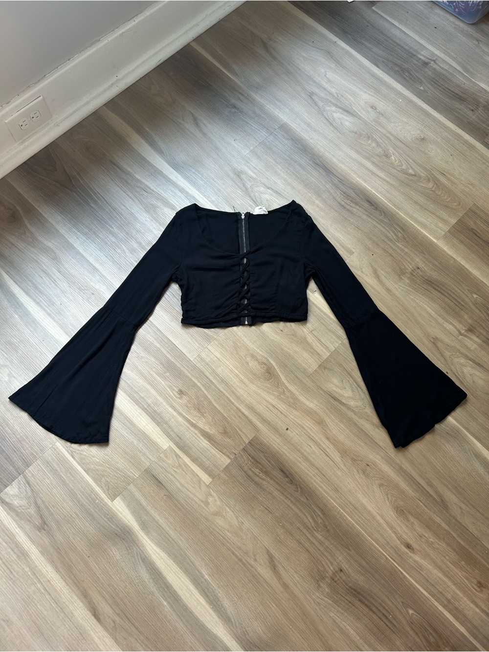 Black long sleeve crop top with zipper detail and flared bell sleeves
